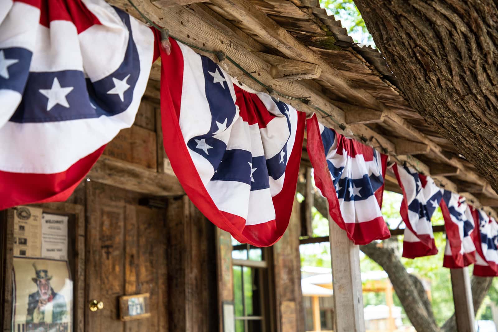 Flag bunting strung along a wooden porch rail