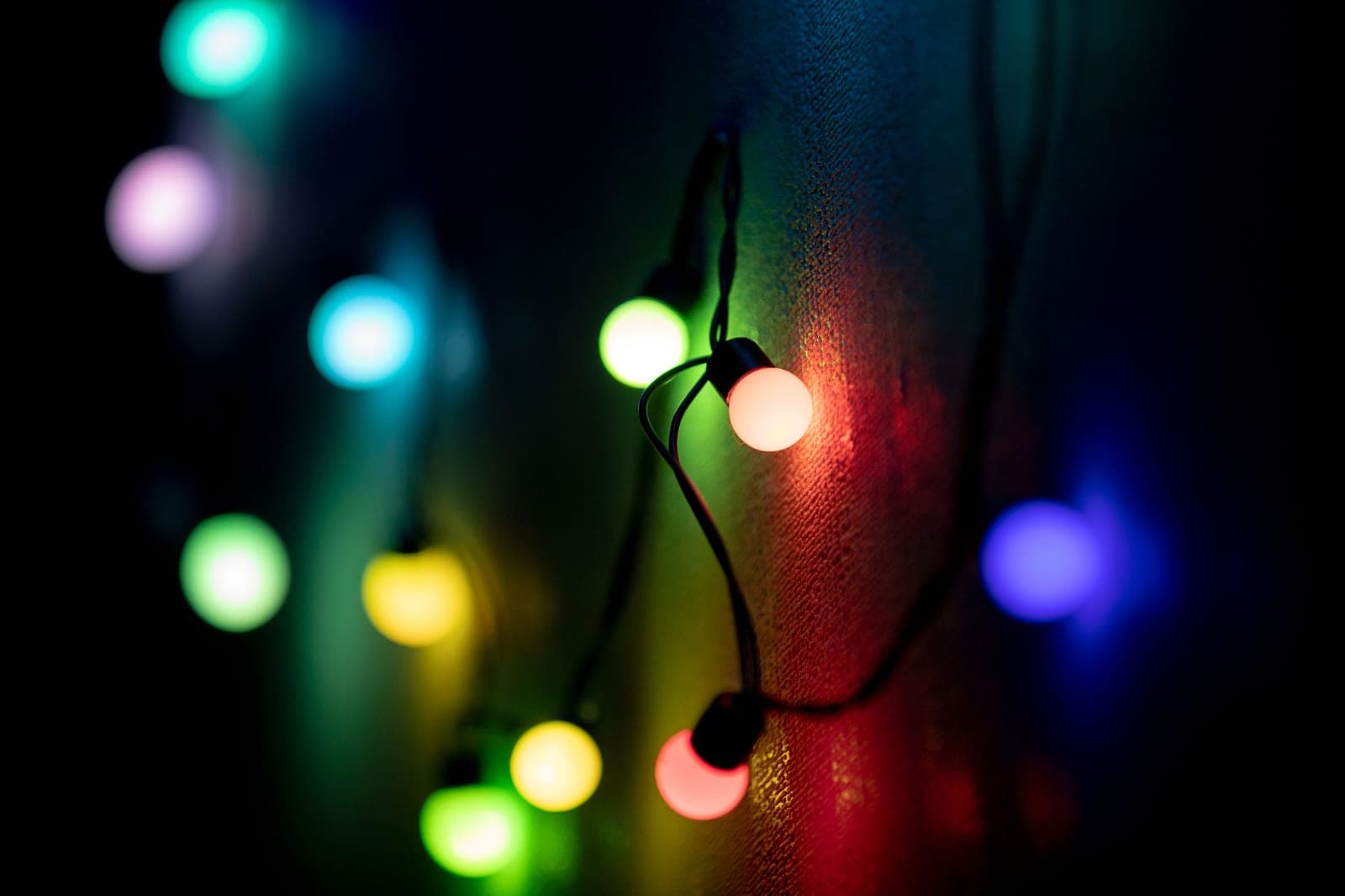 Close-up of colored string lights against a dark background