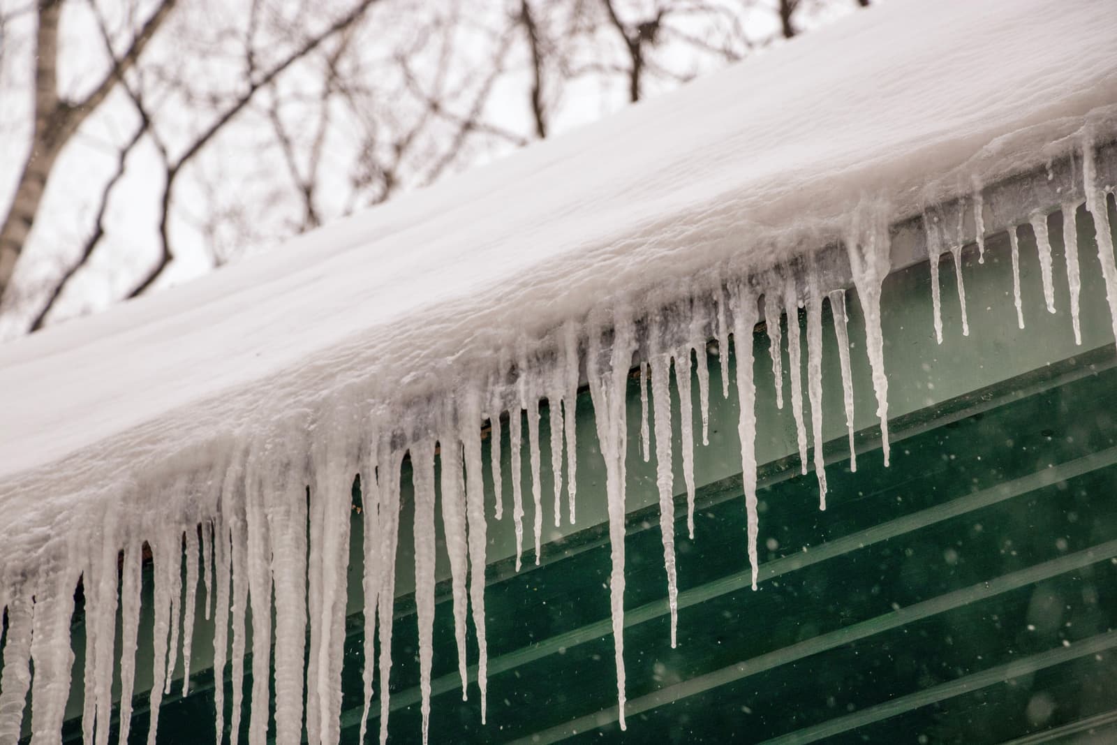 Icicles forming along the edge of a snow-covered roof