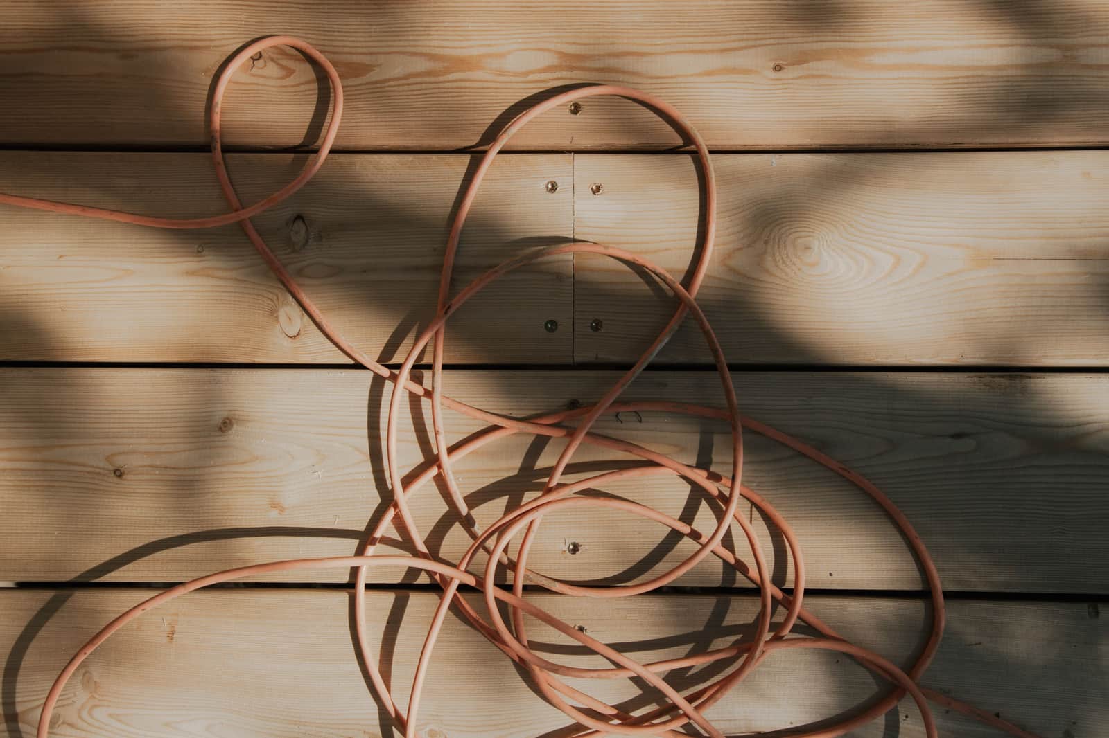 Tangled cable coiled on a wooden surface
